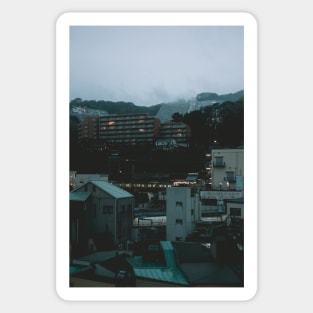 Ito at Dusk with cloud filled mountains in the background Sticker